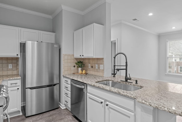 kitchen with light stone counters, visible vents, appliances with stainless steel finishes, white cabinets, and a sink