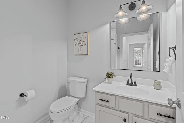 bathroom featuring toilet, marble finish floor, baseboards, and vanity