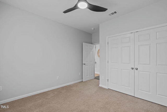 unfurnished bedroom featuring light carpet, baseboards, visible vents, ceiling fan, and a closet