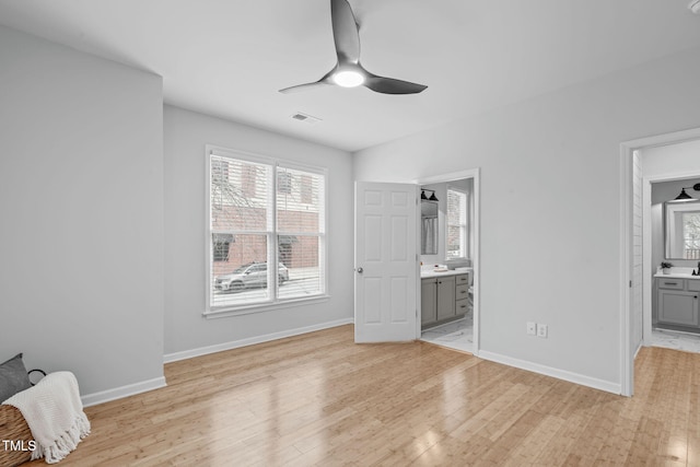 unfurnished bedroom with baseboards, ensuite bath, visible vents, and light wood-style floors