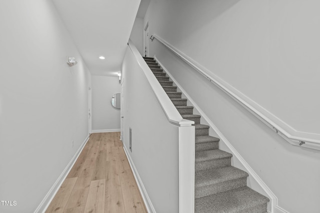 stairway with wood-type flooring and baseboards