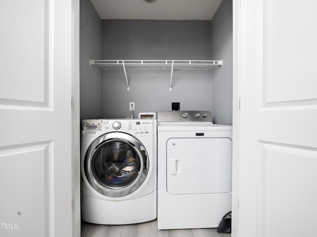 washroom with separate washer and dryer and light hardwood / wood-style floors