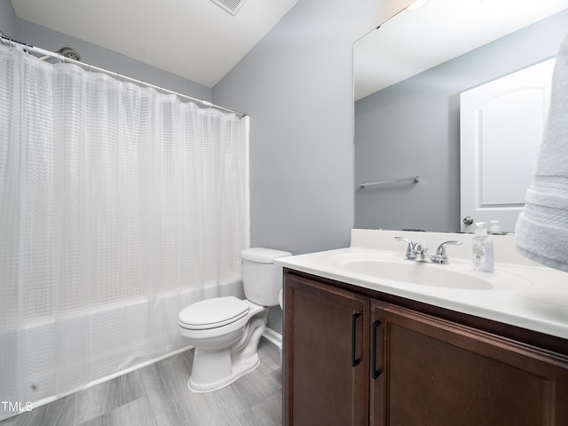 full bathroom featuring shower / tub combo, vanity, hardwood / wood-style flooring, and toilet