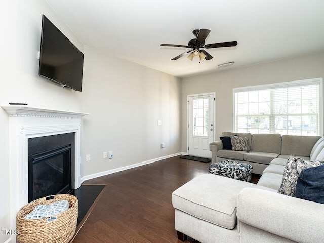 living room with dark wood-type flooring and ceiling fan