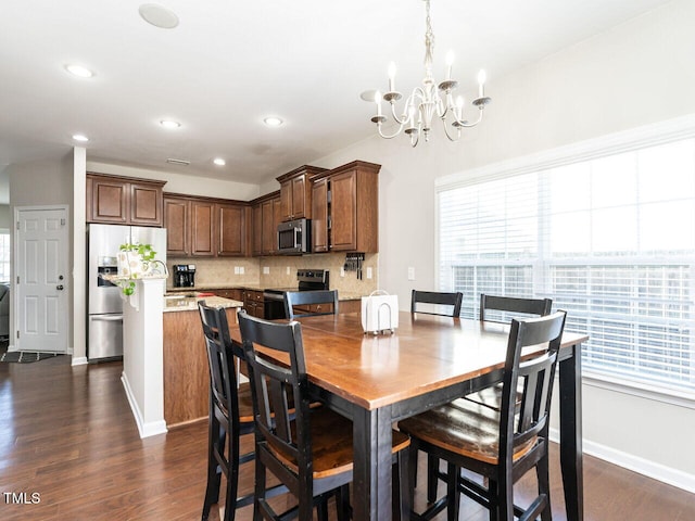 dining space featuring dark wood-type flooring and a chandelier