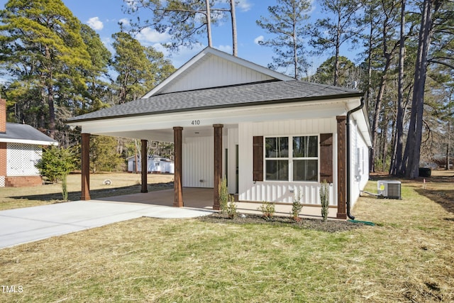 view of front of home with central air condition unit, a front lawn, and a carport