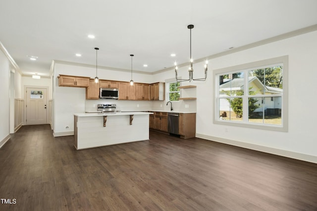 kitchen with dark hardwood / wood-style floors, decorative light fixtures, a center island, decorative backsplash, and appliances with stainless steel finishes