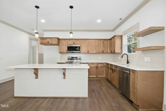 kitchen with decorative light fixtures, stainless steel appliances, a kitchen island, dark hardwood / wood-style flooring, and sink