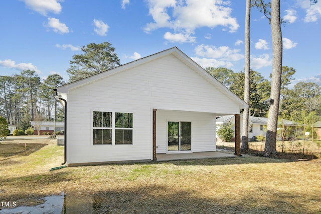 back of house featuring a patio area and a lawn