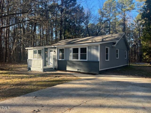 108 Seabreeze Rd, Hertford, NC 27944 - view of front of house featuring concrete driveway, board and batten siding, crawl space, and view of wooded area