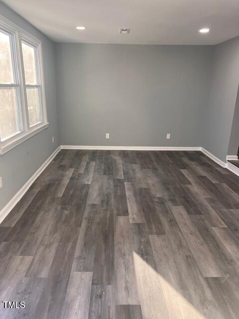 empty room with dark hardwood / wood-style flooring