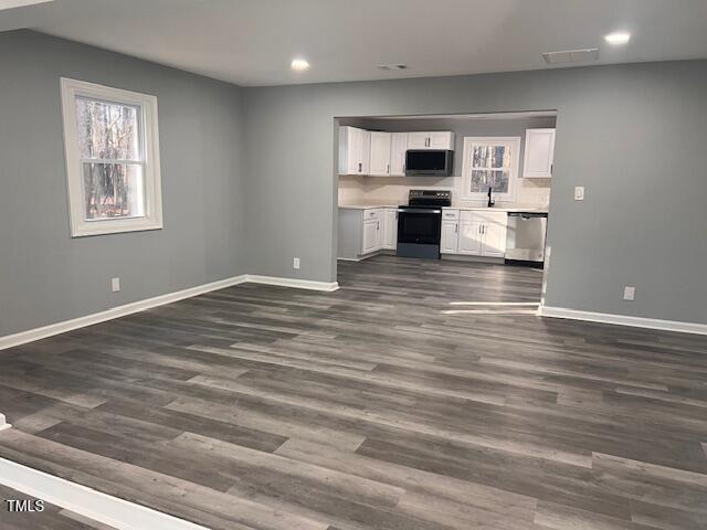 kitchen featuring dark wood-type flooring, white cabinets, stainless steel appliances, and sink