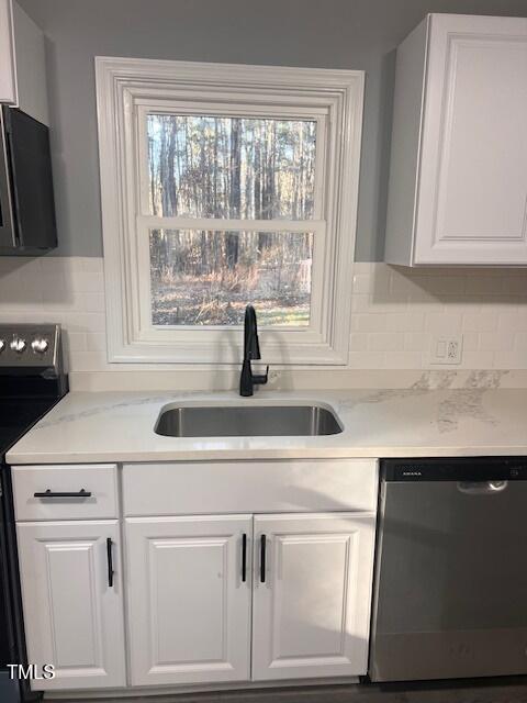 kitchen featuring dishwasher, range, white cabinetry, and sink