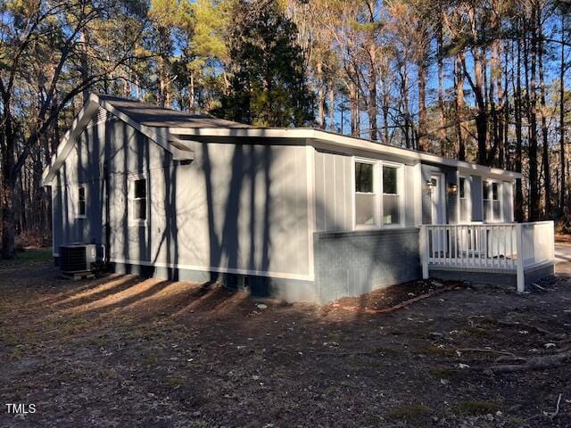 view of property exterior with cooling unit and a wooden deck