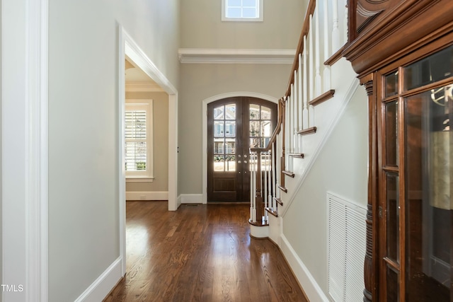 foyer entrance featuring french doors, ornamental molding, and dark wood-type flooring