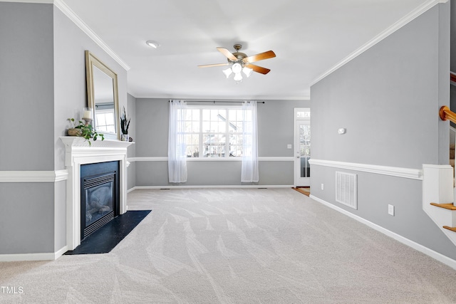 unfurnished living room with ceiling fan, plenty of natural light, carpet, and ornamental molding