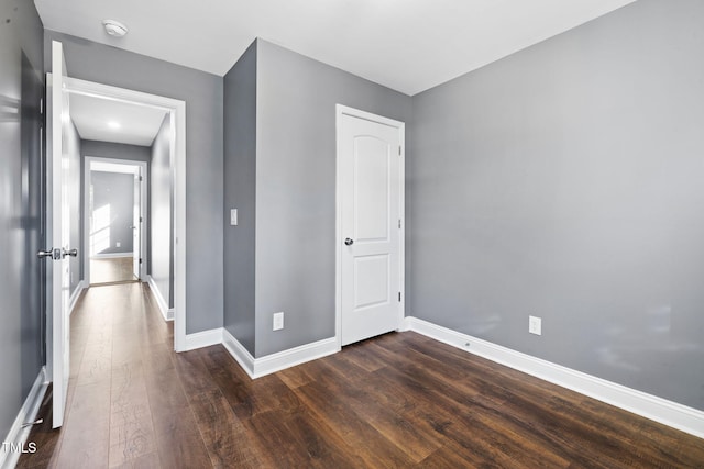 empty room with dark hardwood / wood-style flooring