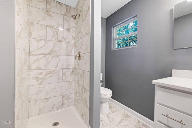 bathroom with vanity, toilet, and a tile shower