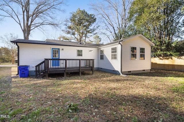 back of property featuring a deck and a yard