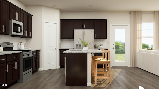 kitchen featuring a breakfast bar, a center island, stainless steel appliances, and tasteful backsplash