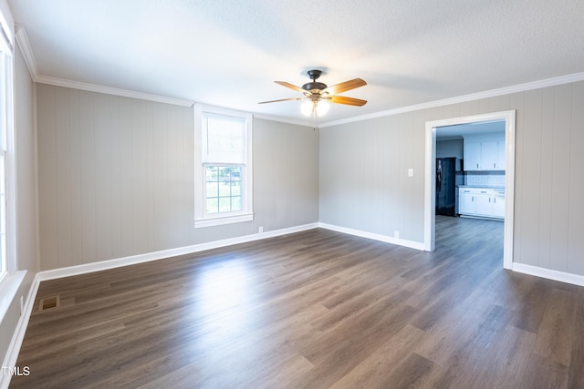 spare room featuring ceiling fan, dark wood-type flooring, a textured ceiling, and ornamental molding