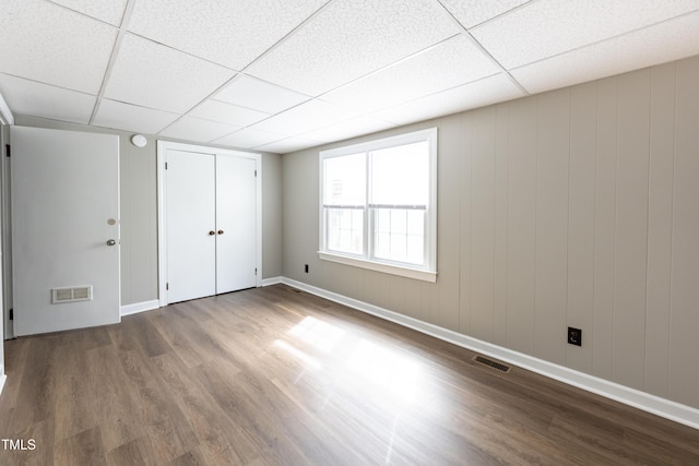 interior space with hardwood / wood-style floors and a drop ceiling