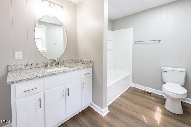 full bathroom with wood-type flooring, vanity, bathing tub / shower combination, and toilet