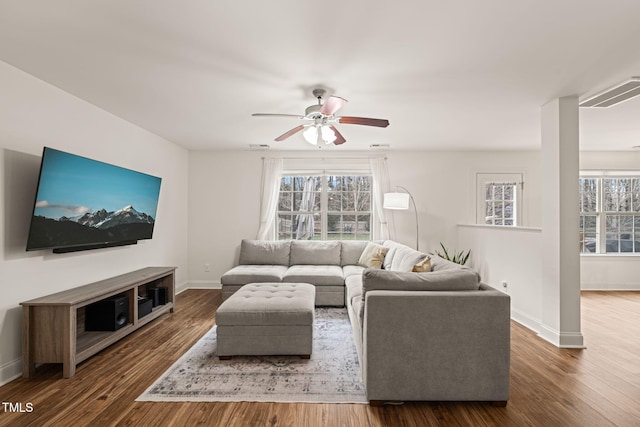 living room with ceiling fan, dark wood-type flooring, and a wealth of natural light