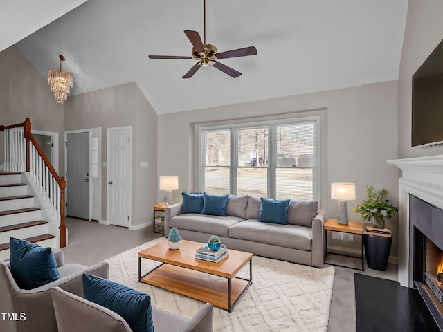 living room featuring ceiling fan with notable chandelier, light colored carpet, and vaulted ceiling