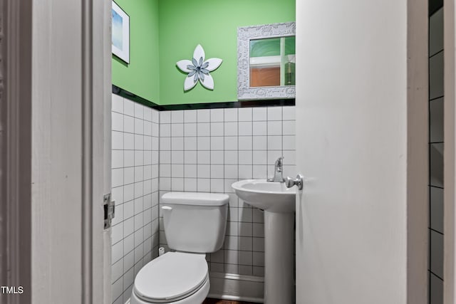 bathroom featuring tile walls and toilet