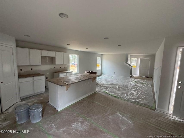 kitchen featuring white cabinetry, a kitchen island, and a breakfast bar