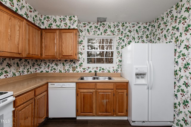 kitchen with dark hardwood / wood-style flooring, white appliances, and sink