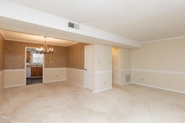 carpeted empty room with sink, crown molding, and a chandelier