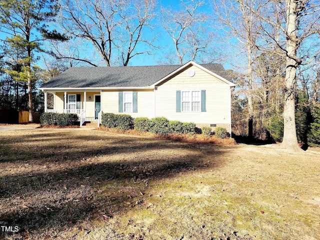 ranch-style house featuring covered porch and a front yard