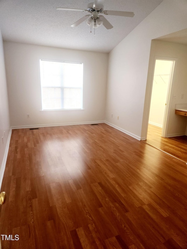 spare room featuring wood-type flooring, a textured ceiling, and ceiling fan