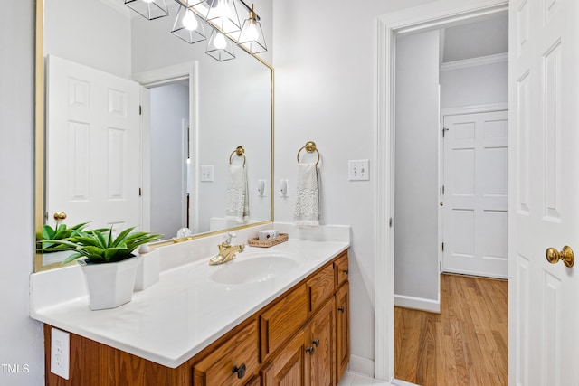 bathroom with vanity, ornamental molding, and hardwood / wood-style flooring