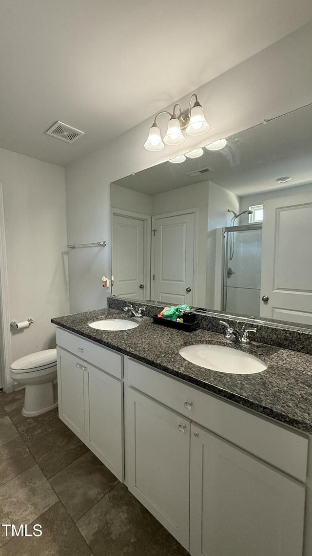 bathroom featuring vanity, toilet, and a shower with door