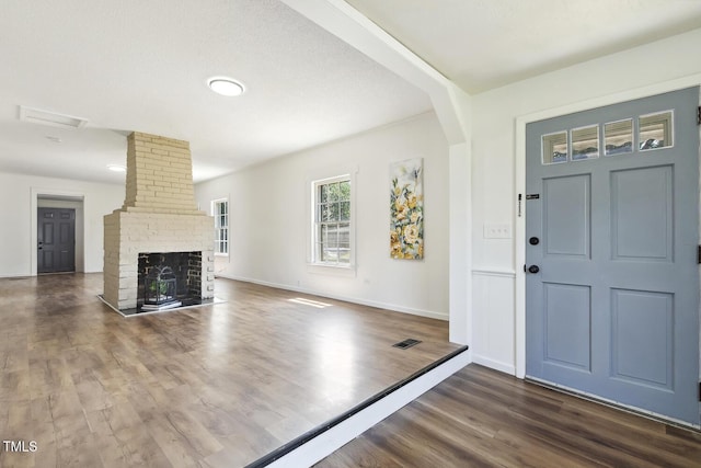 entrance foyer featuring a fireplace and dark hardwood / wood-style floors