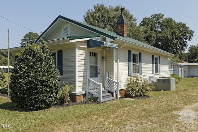 view of front of property featuring central air condition unit and a front lawn