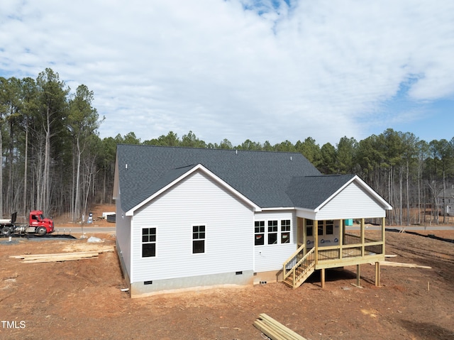 back of house featuring crawl space and roof with shingles