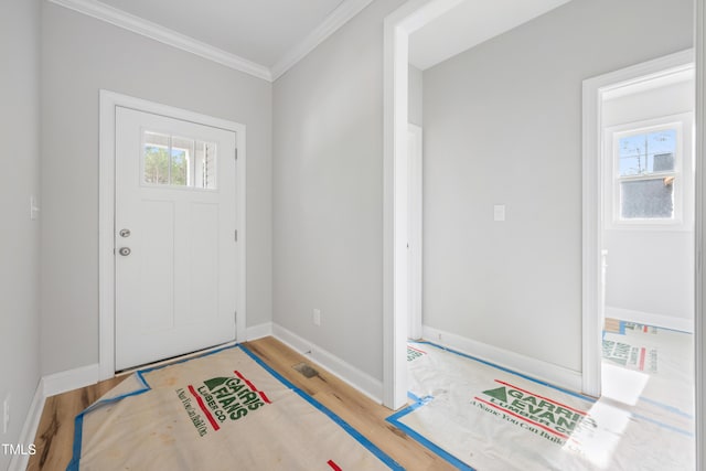 entrance foyer with baseboards, wood finished floors, and ornamental molding