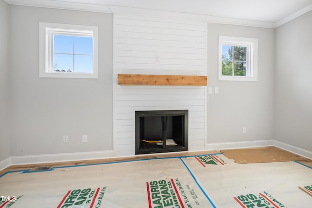 unfurnished living room with a fireplace, wood finished floors, baseboards, and ornamental molding