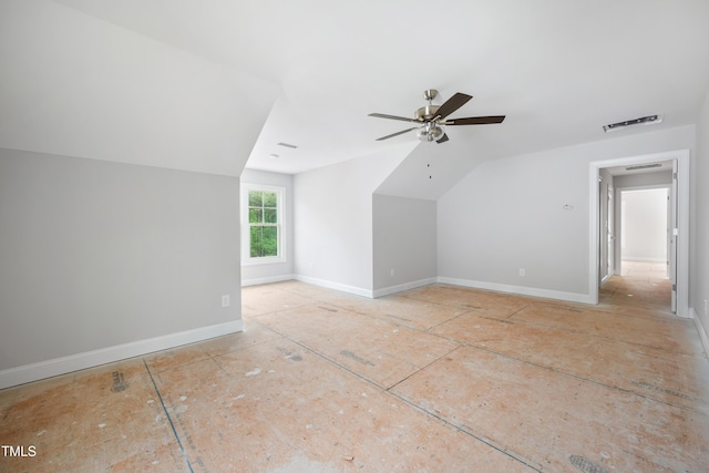 additional living space featuring vaulted ceiling, visible vents, a ceiling fan, and baseboards