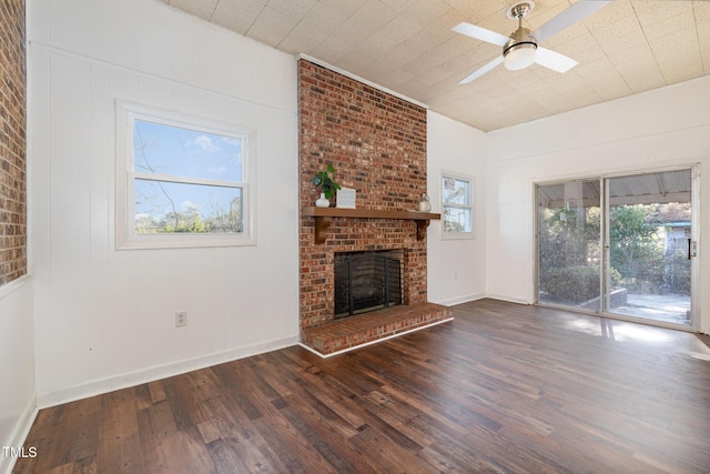 unfurnished living room with ceiling fan, a fireplace, and dark wood-type flooring