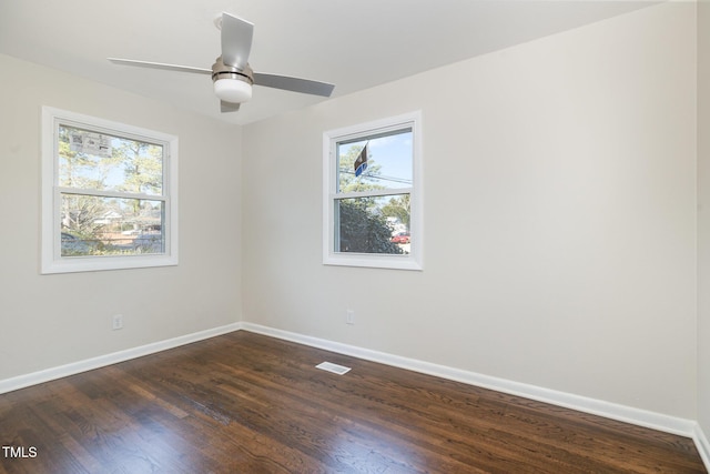 unfurnished room with ceiling fan, a healthy amount of sunlight, and dark wood-type flooring