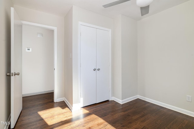 unfurnished bedroom featuring a closet, dark hardwood / wood-style floors, and ceiling fan