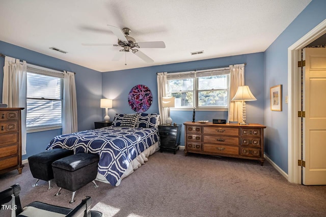 bedroom featuring ceiling fan, multiple windows, and carpet floors