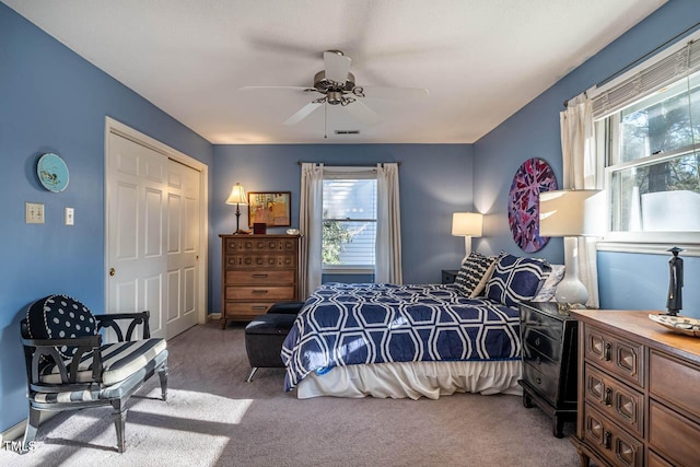 bedroom featuring carpet flooring, ceiling fan, a closet, and multiple windows