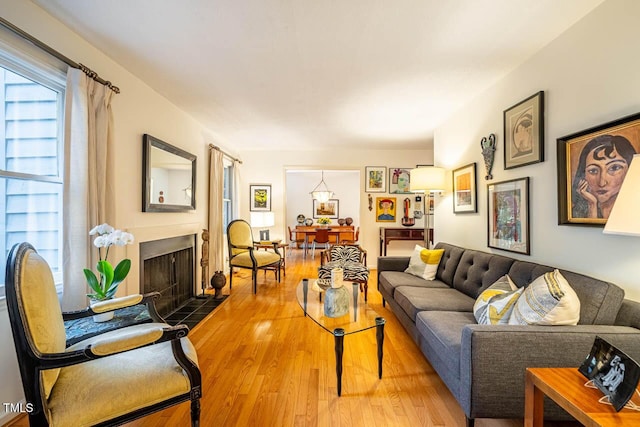 living room featuring a tiled fireplace and hardwood / wood-style floors