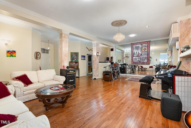 living room featuring decorative columns, light hardwood / wood-style floors, and crown molding